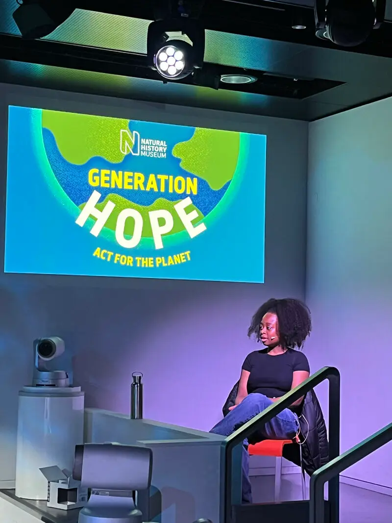 Image of Fancisca speaking at an event for generation hope, sat in a studio with a microphone